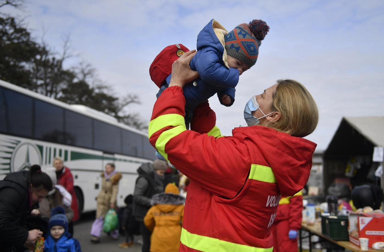 Un voluntario cuida a un niño cuando miles de mujeres y niños cruzan la frontera tras los ataques rusos en el cruce fronterizo de Siret en Siret, Rumania.