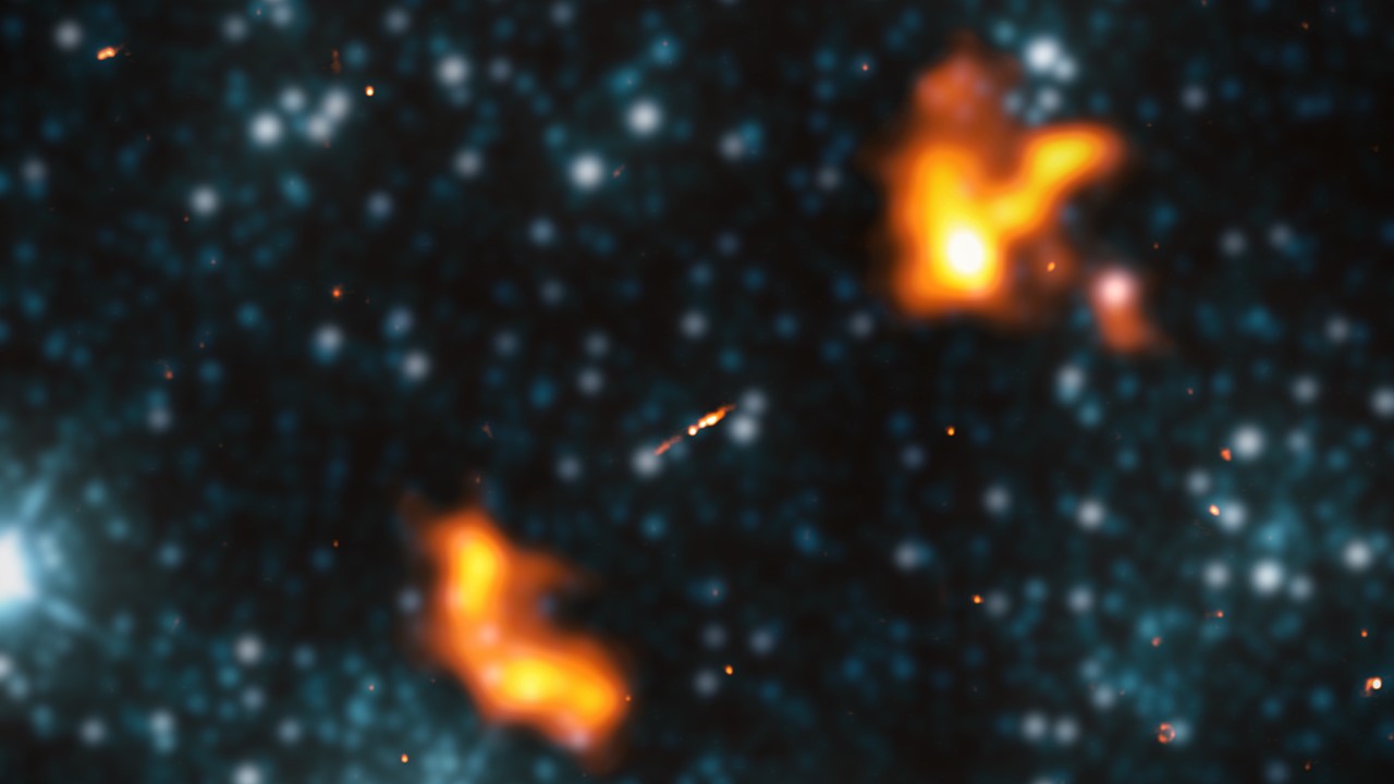 Foto de la radiogalaxia Alkyoneus, que es 100 veces más grande que la Vía Láctea.  Las manchas naranjas son una ráfaga de ondas de radio disparadas desde ambos lados del objeto.