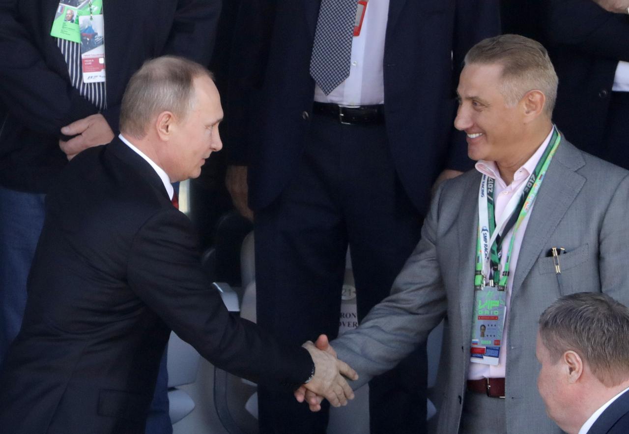 El presidente Putin (izquierda) le da la mano a su compañero de entrenamiento de judo Boris Rotenberg (izquierda)