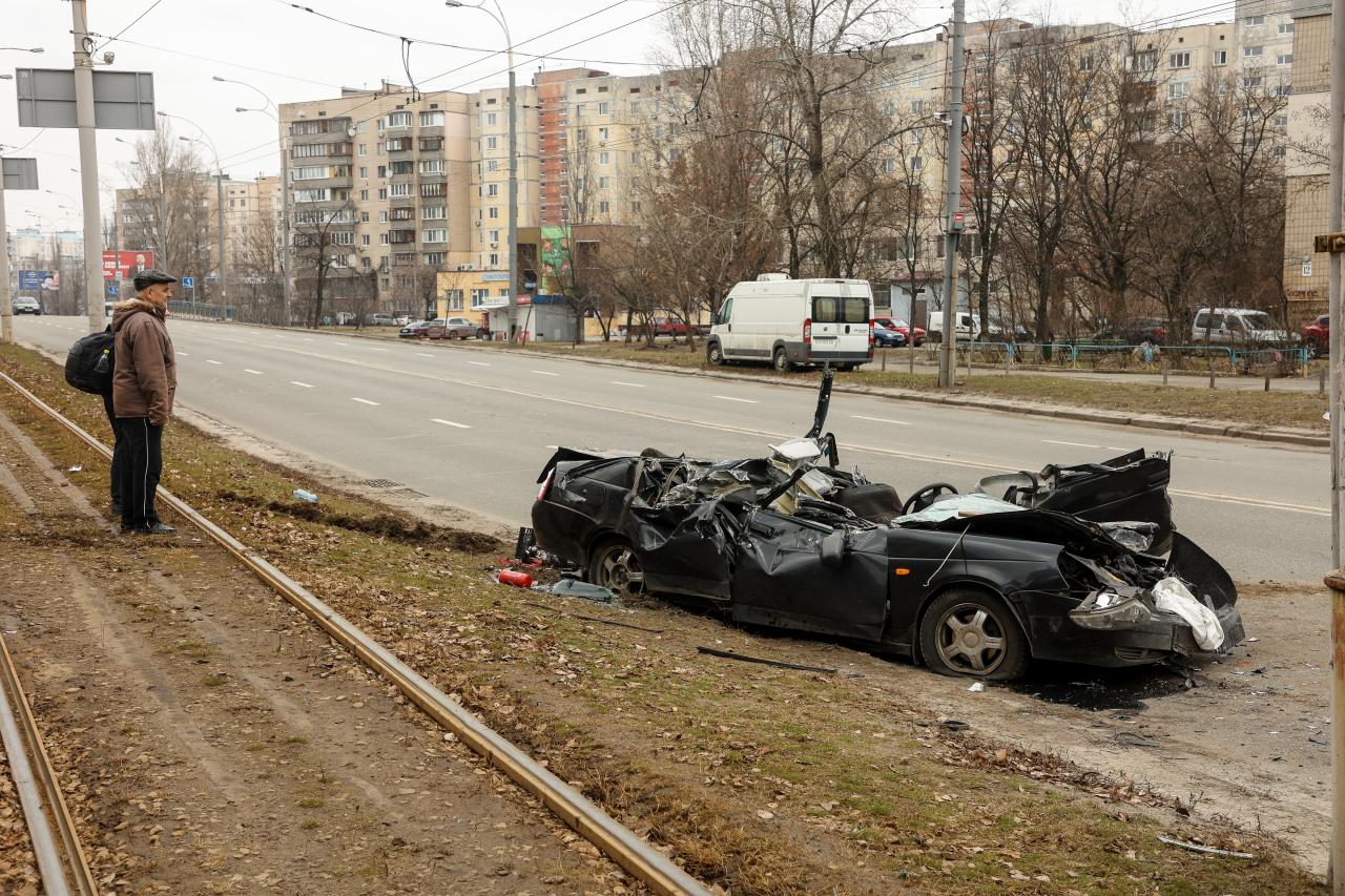 Los residentes miran los restos aplastados de un automóvil en Kiev
