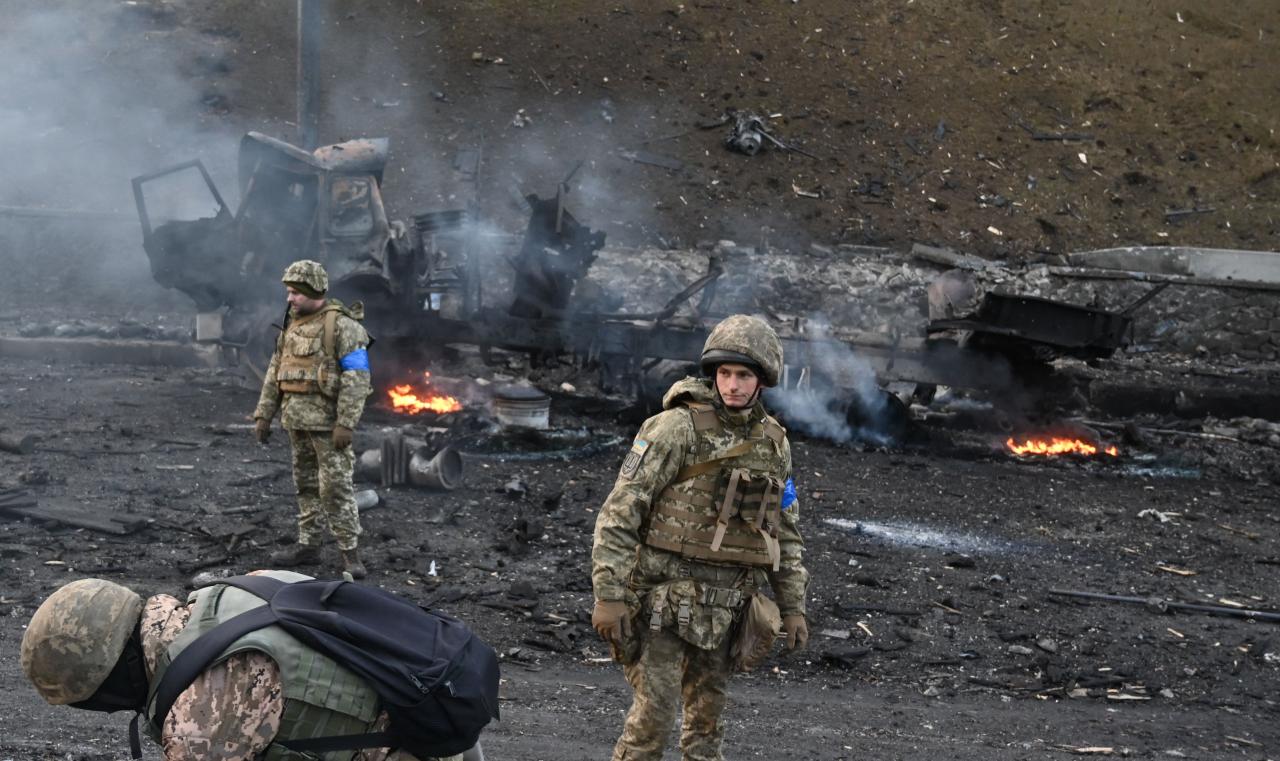 Soldados ucranianos junto a un vehículo en llamas, la lucha continúa en Kiev