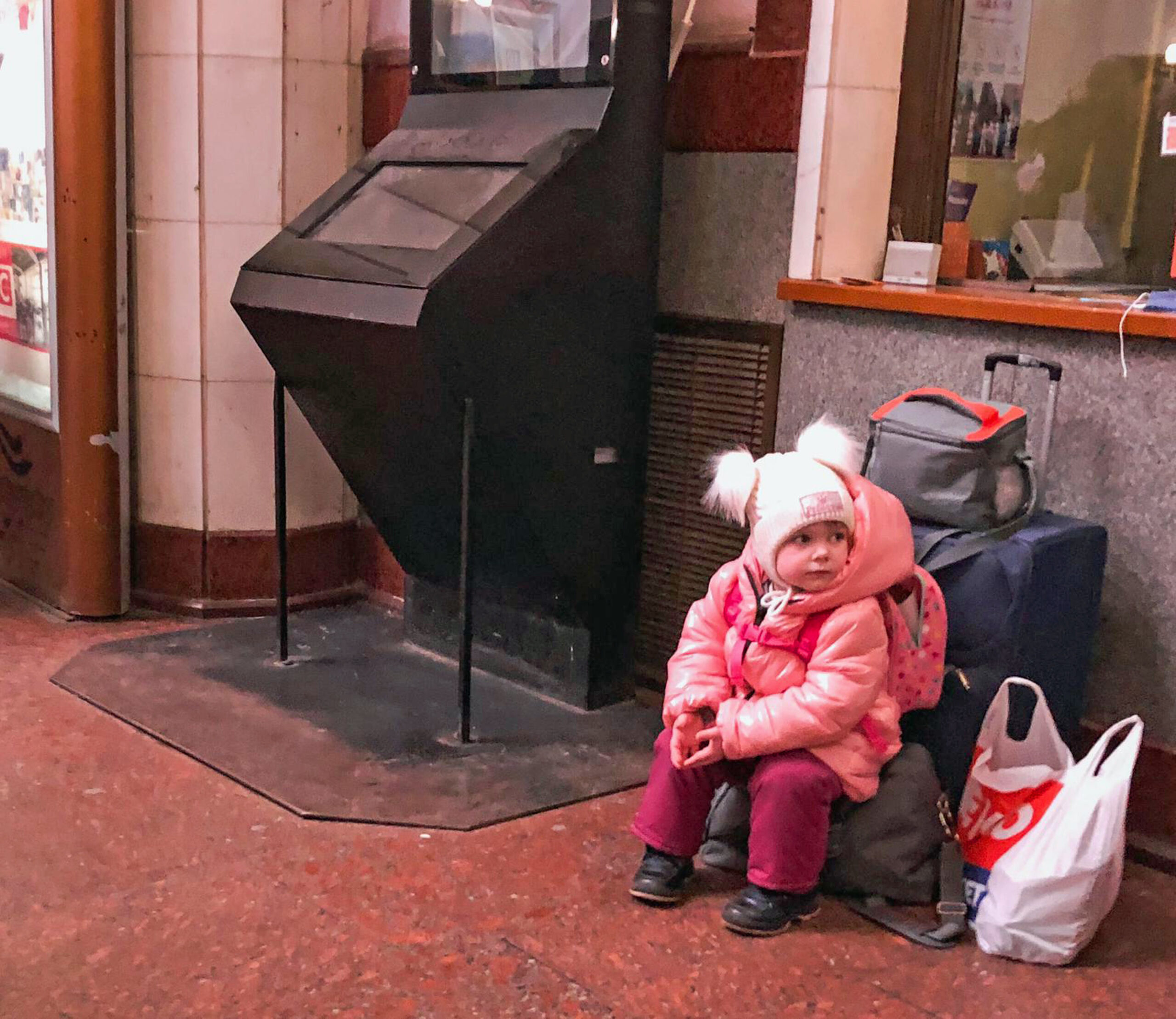 Una niña que huye de Ucrania espera en la estación de tren de Lviv