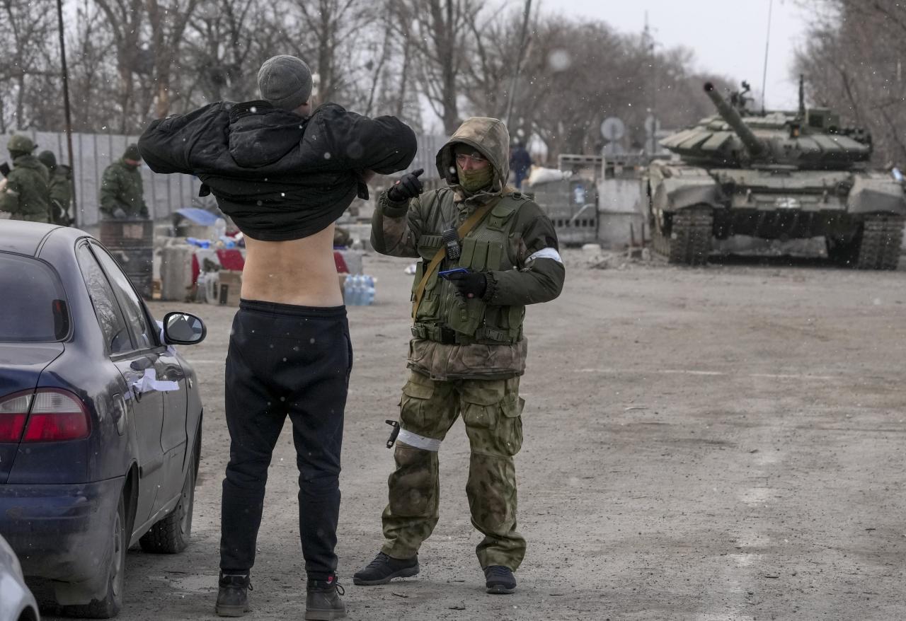 Un civil en el puesto de control está siendo registrado por separatistas prorrusos en Mariupol.