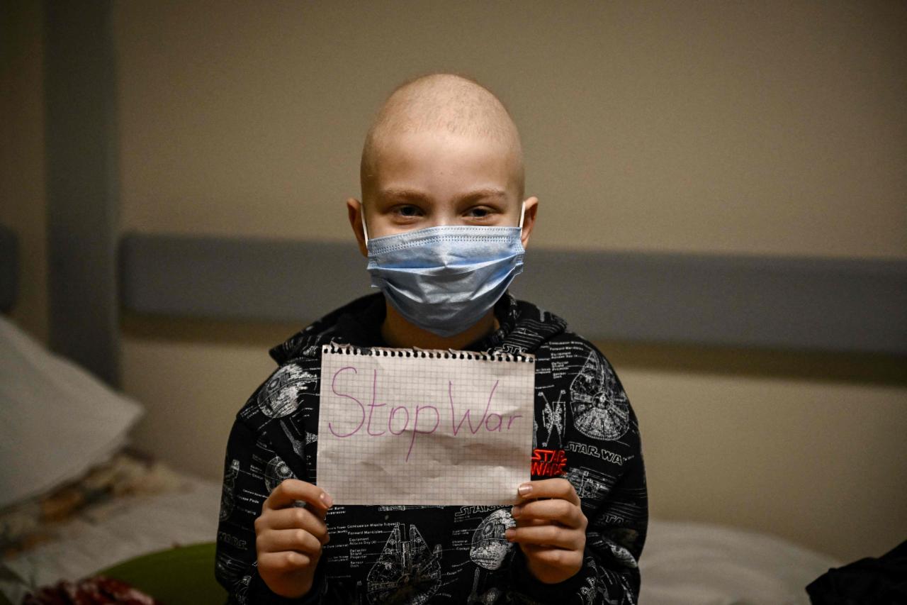 Un paciente con cáncer sostiene un cartel en un hospital de Kiev.