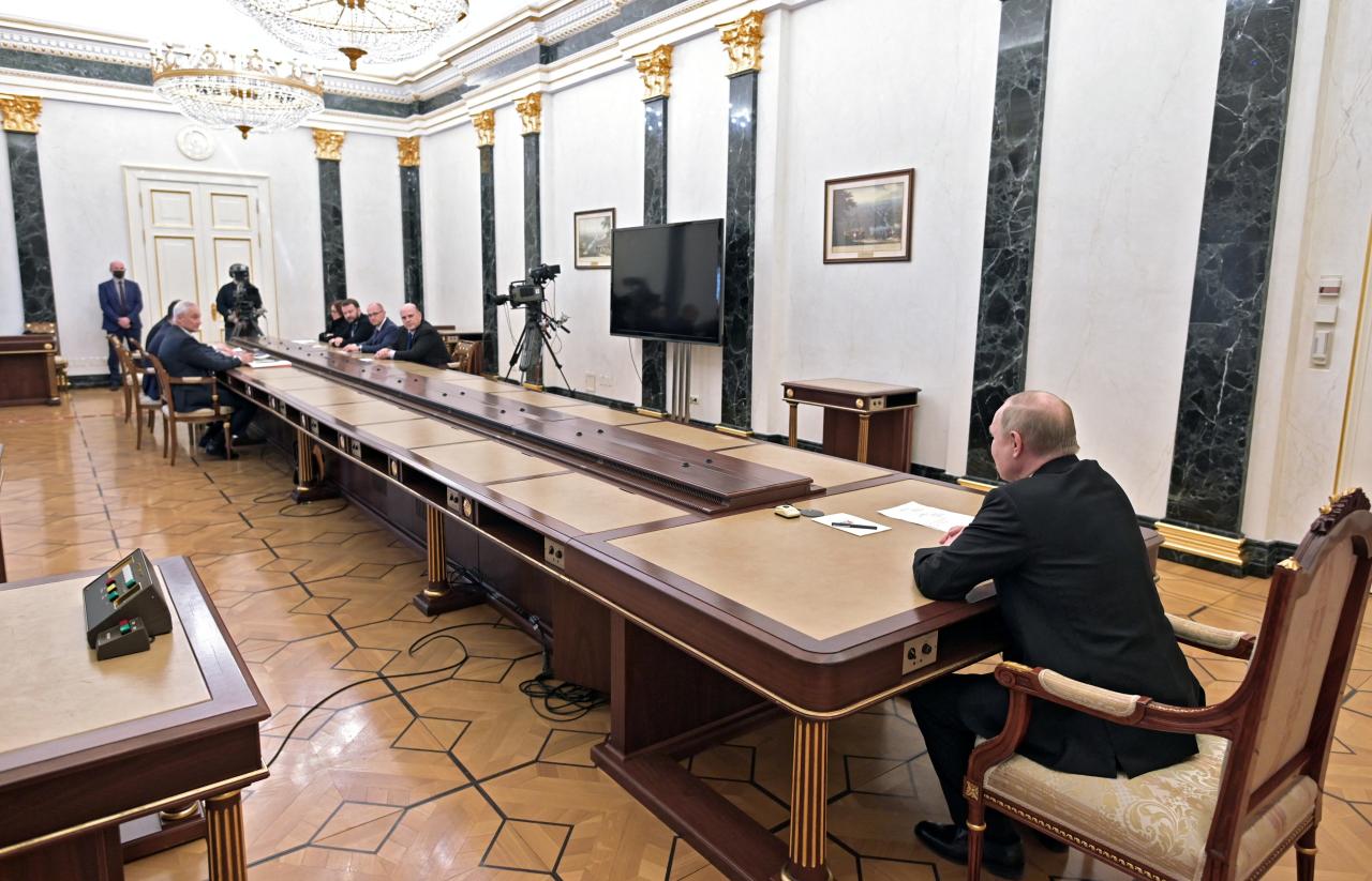 En la foto, el déspota ruso estaba sentado a una distancia considerable de sus asesores.