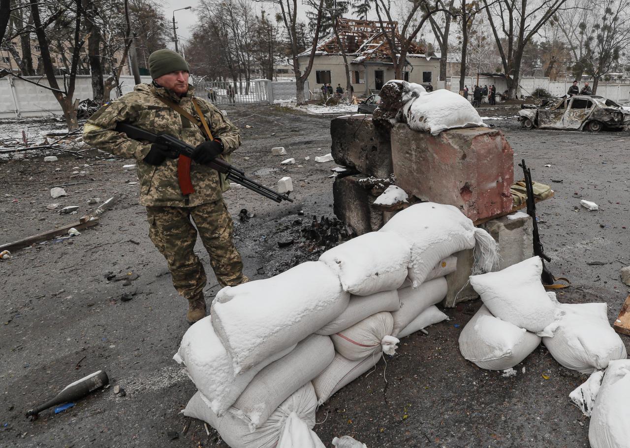 Soldados ucranianos de pie después del bombardeo nocturno en el puesto de control ucraniano cerca de Kiev