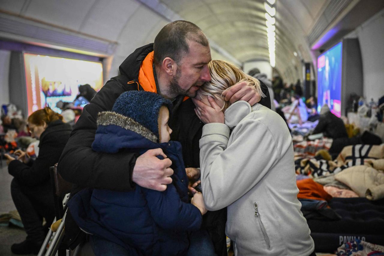 Sergei Badylevych, de 41 años, abraza a su esposa Natalia y a su hijo en una estación subterránea utilizada como refugio antiaéreo en Kiev.