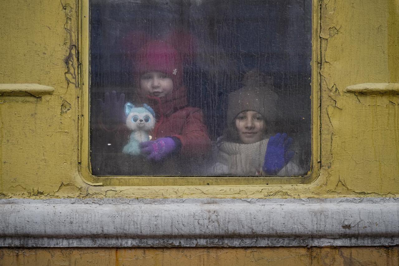 Los niños miran por la ventana del tren a Lviv en Kiev