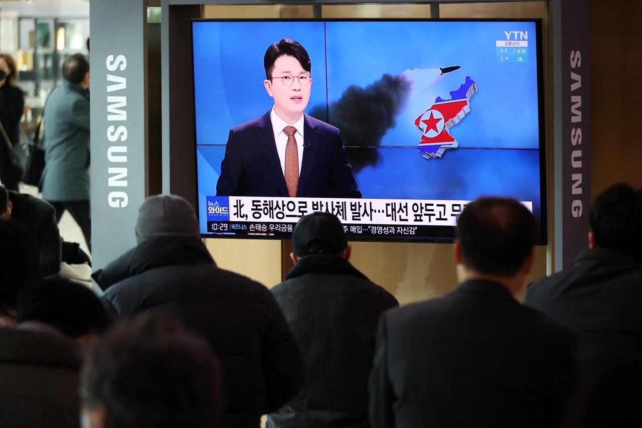 La gente mira la transmisión televisiva sobre las noticias del lanzamiento de un misil balístico de Corea del Norte frente a su costa este en Seúl, Corea del Sur.