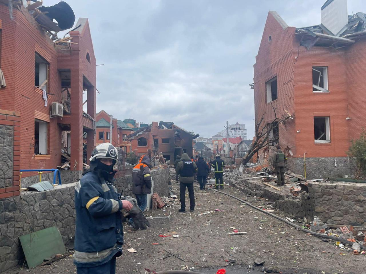 Los equipos de rescate están trabajando en un sitio donde varias casas resultaron dañadas por una explosión después de un ataque aéreo en Biała Cerkiew en Kiev.
