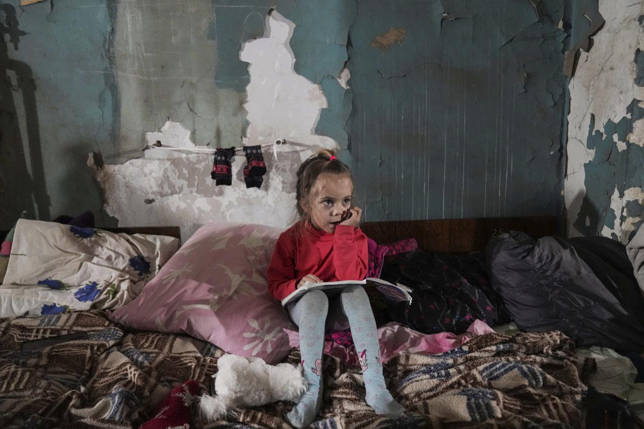 La niña está sentada en un refugio antiaéreo improvisado en Mariupol.