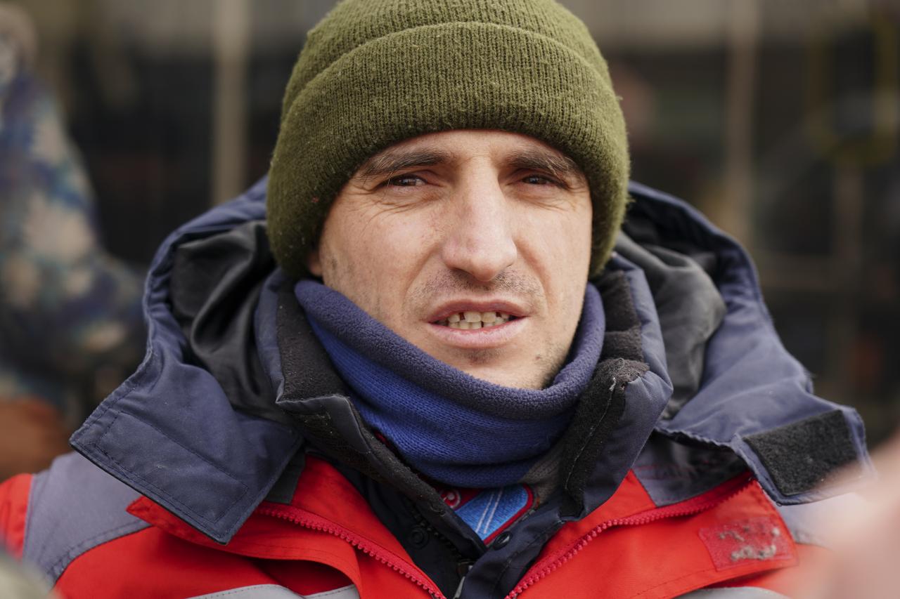 Volodymyr Kuczarski, de 32 años, ayuda a los viajeros a subir a los autobuses