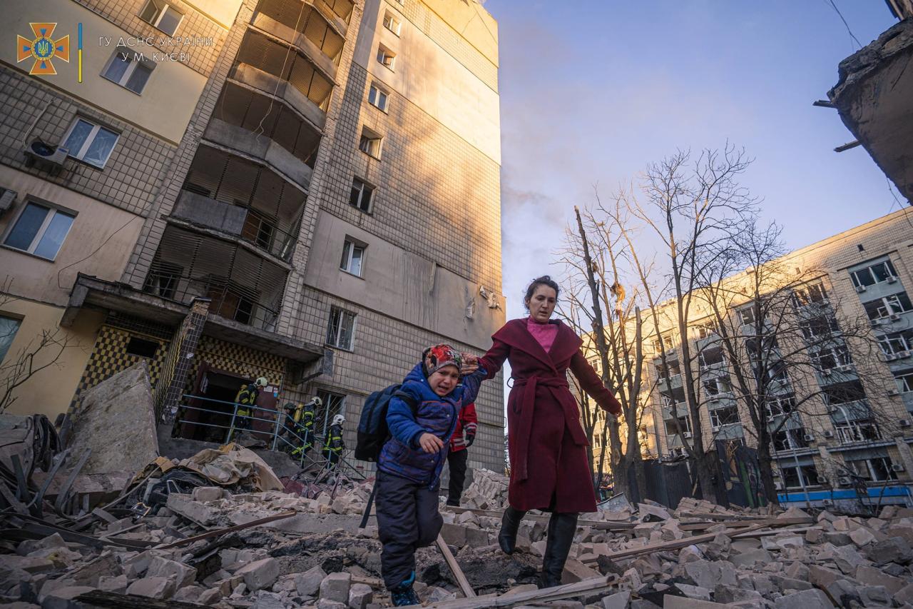 La vida en ruinas cuando una mujer y un niño escapan de un edificio bombardeado en Kiev