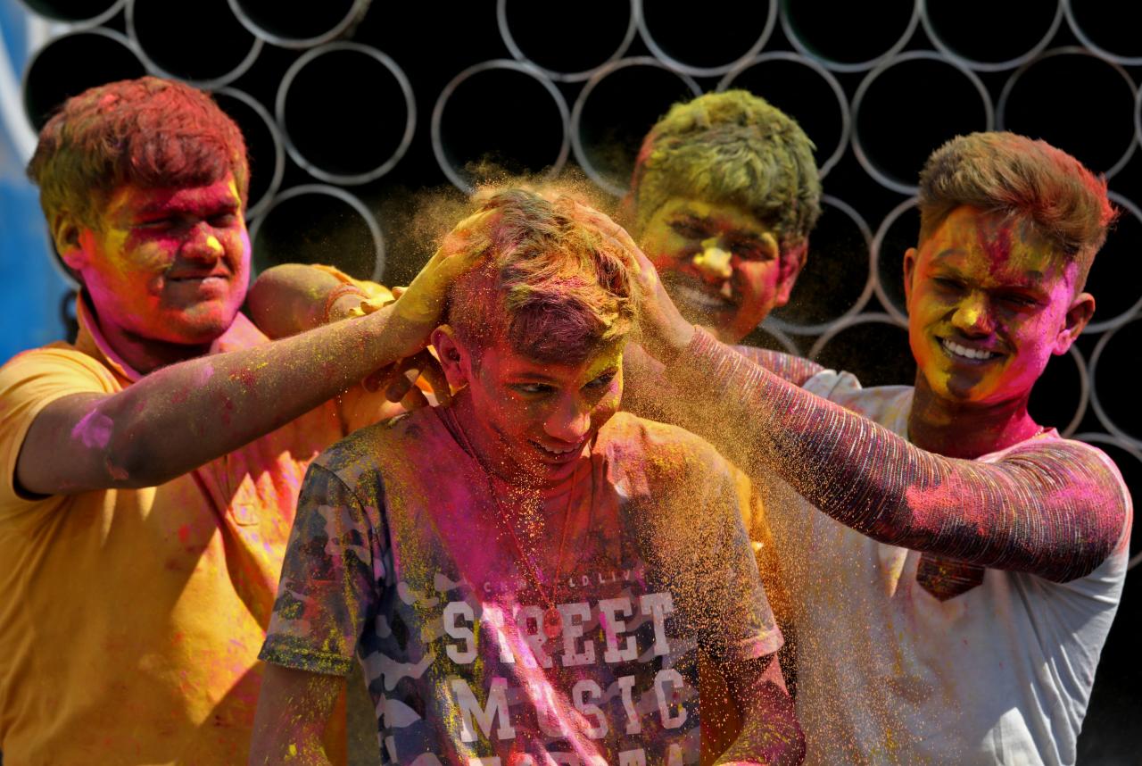 El niño reacciona cuando le arrojan polvo de colores en la cabeza en Calcuta, India