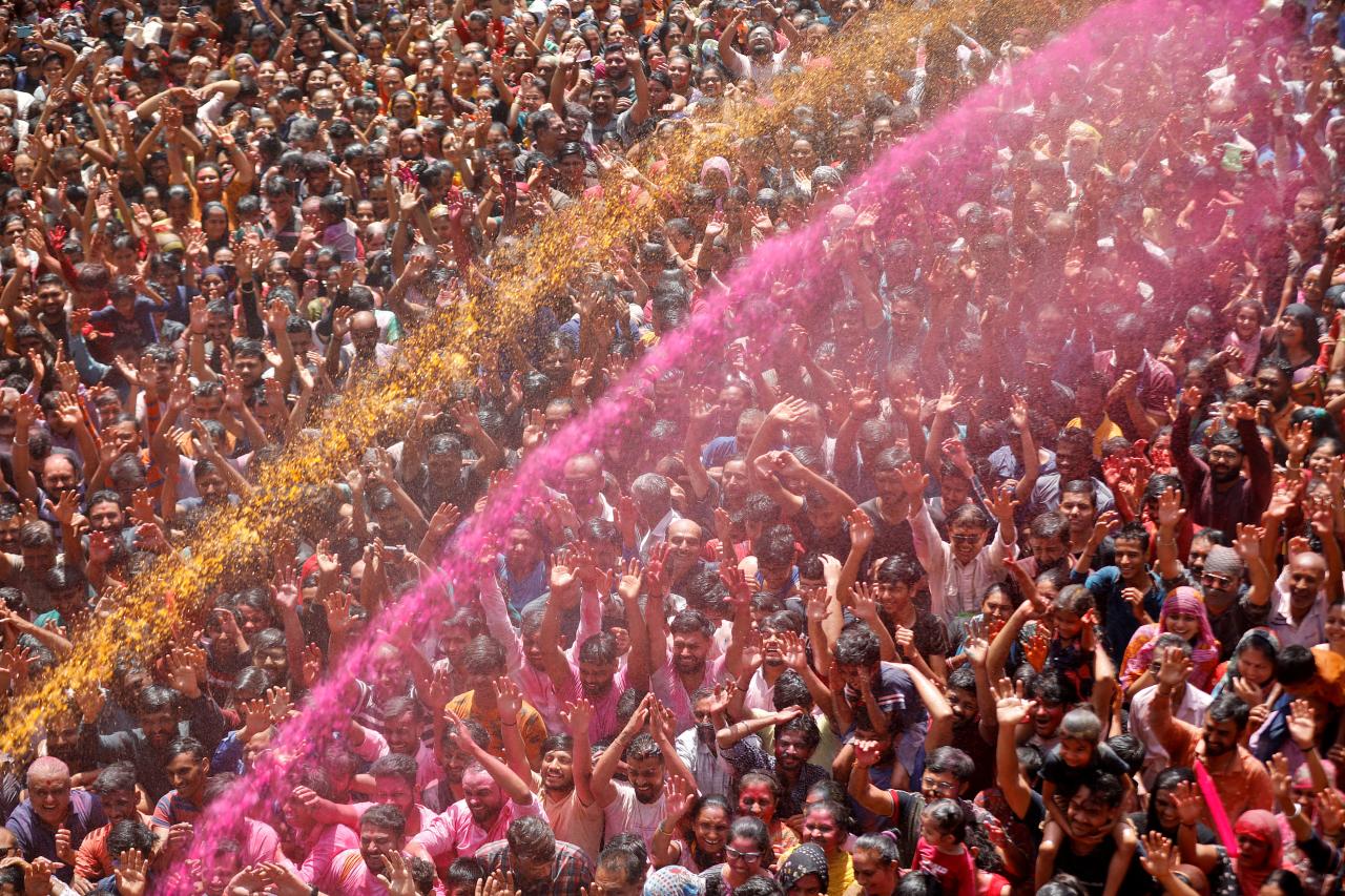 Los hindúes rezan rociándolos con agua coloreada durante la celebración de Holi en Ahmedabad, India.