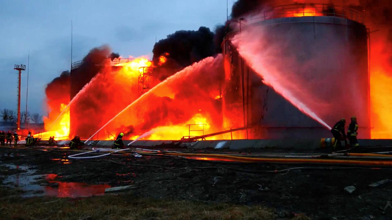 Los bomberos, algunos con equipo de calefacción, se ocupan de un incendio en un depósito de combustible cerca de Lviv