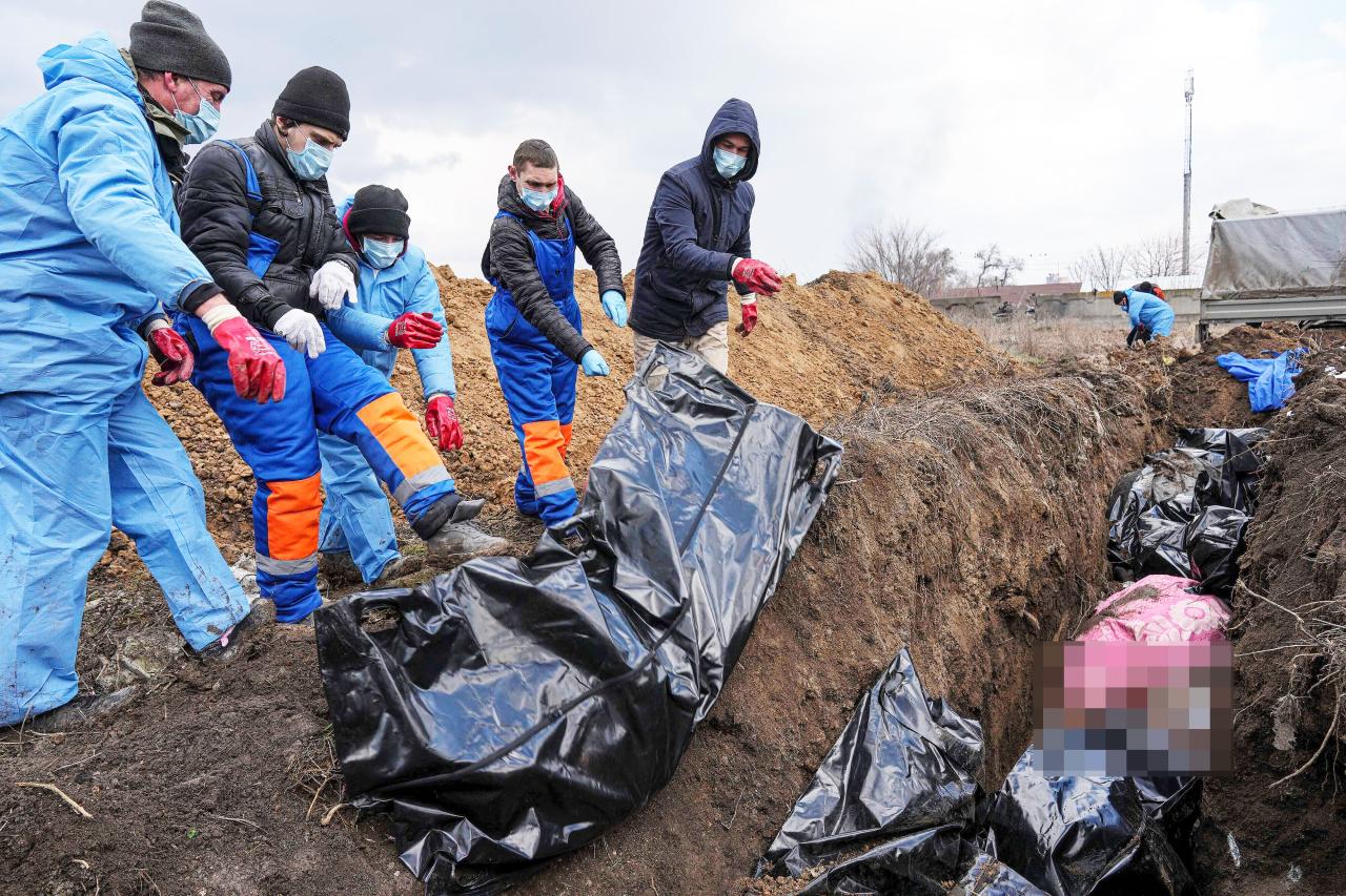 Familias desesperadas entierran a sus muertos en fosas comunes en Mariupol