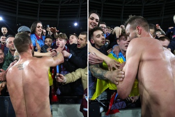 Yarmolenko entrega la camiseta a un aficionado que sostiene la bandera de Ucrania después de que el ganador del West Ham haya marcado