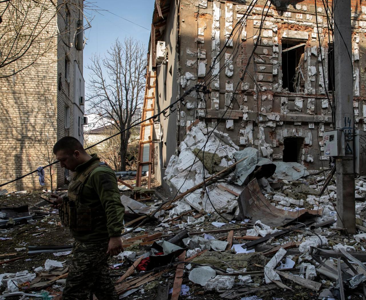 Un soldado militar ucraniano camina sobre los escombros después del bombardeo ruso en Kharkiv.