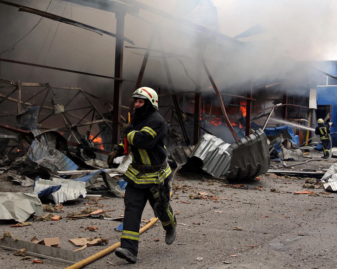 Un bombero está tratando de extinguir un incendio que estalló en un almacén de acero en Kharkiv