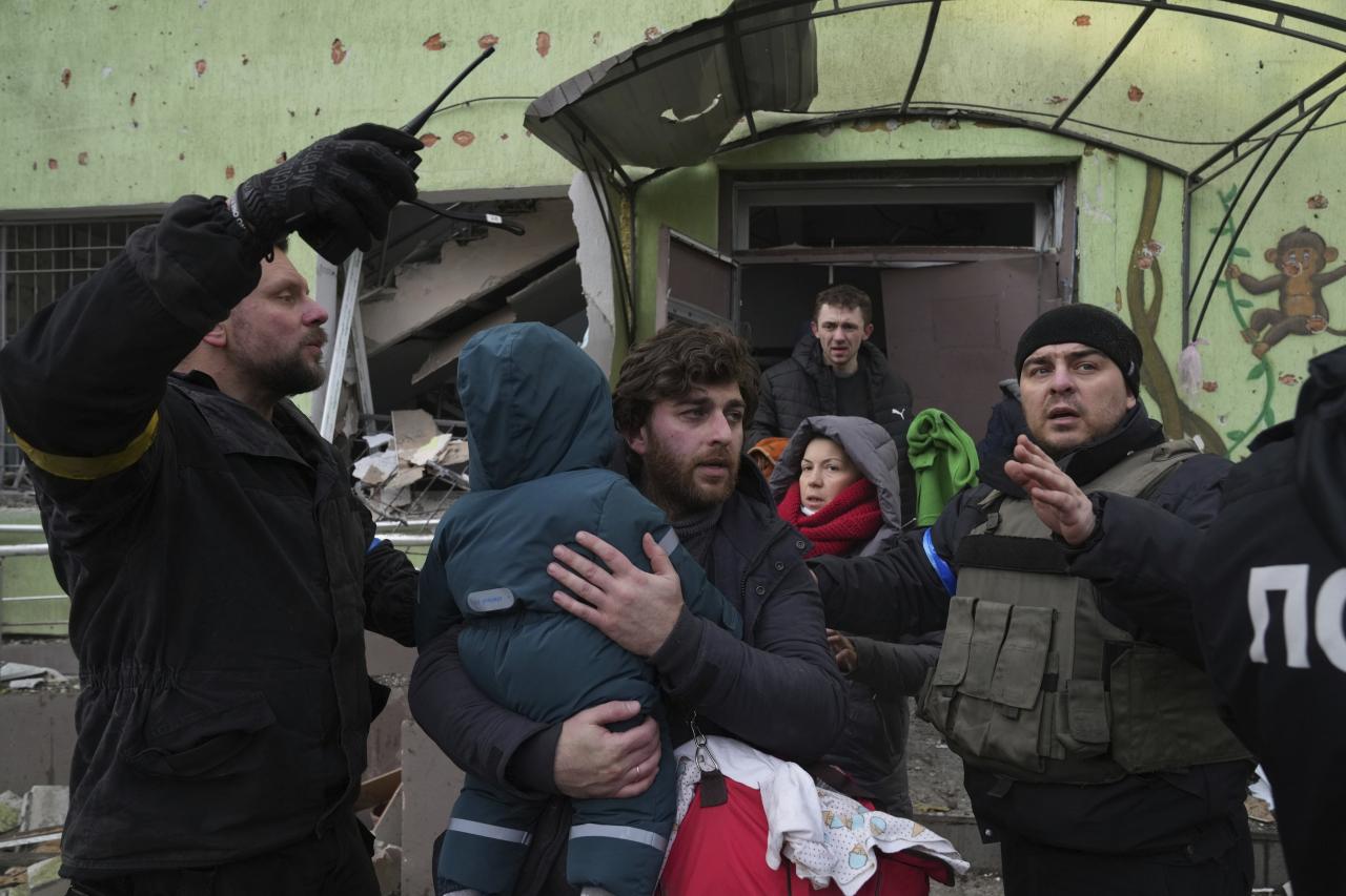El hombre saca al niño del hospital de maternidad en Mariupol, Ucrania, destruido por el fuego