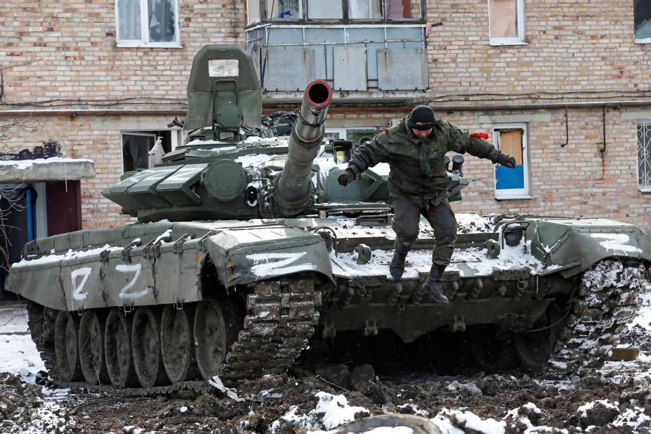 Un miembro del servicio de las tropas prorrusas en uniforme sin insignias salta de un tanque con las letras 