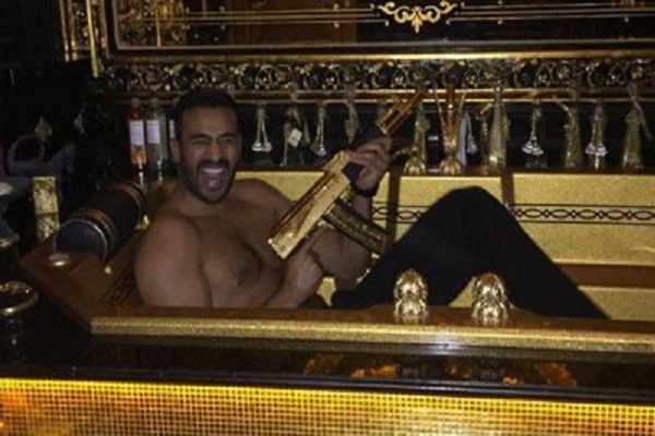 El compañero kickboxer de Ramzan Kadyrov, Badr Hari, posa con un caudillo dorado AK-47 en una bañera dorada.