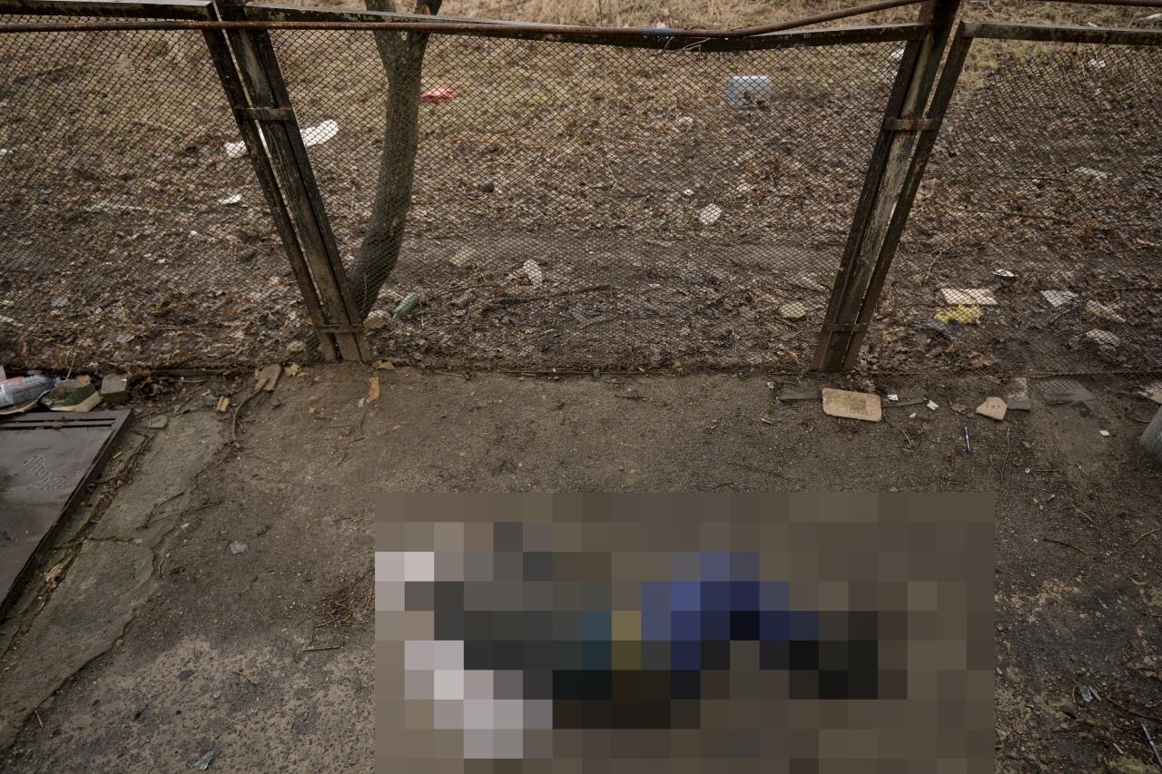 El cadáver de un hombre con las manos atadas a la espalda yace en el suelo en Bucha el domingo.