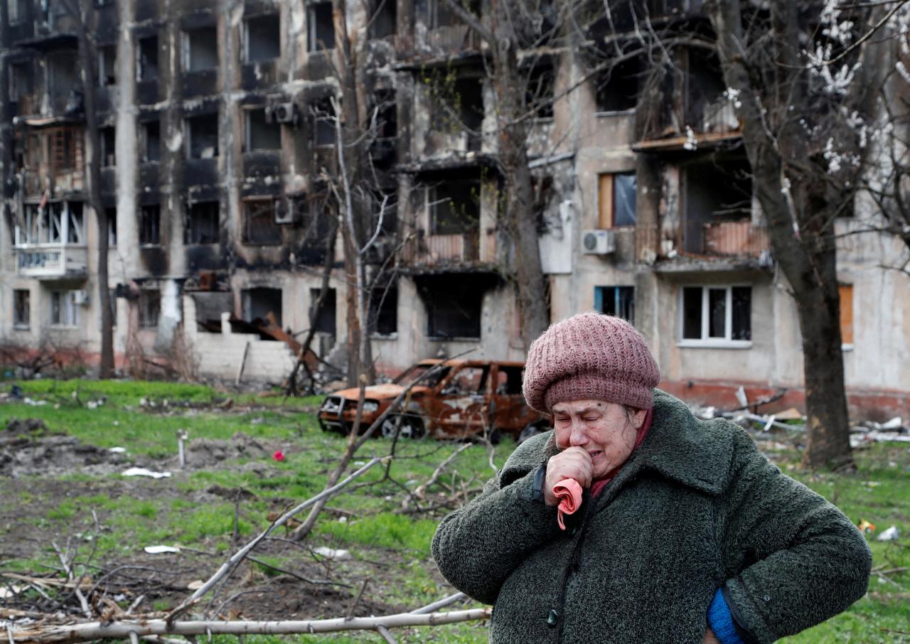 Tamara, de 71 años, llora frente a un edificio de apartamentos destruido por las tropas rusas
