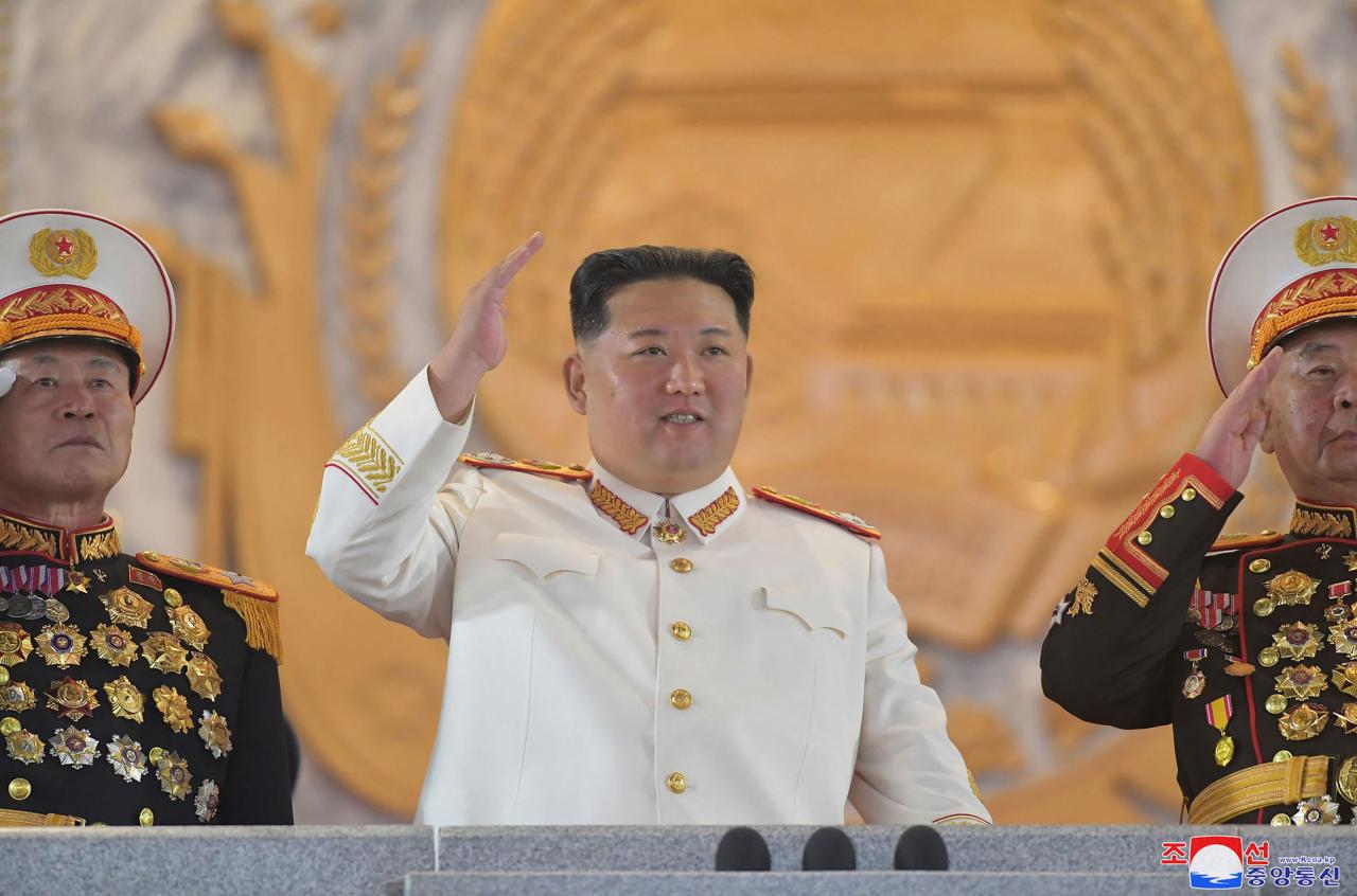 Kim Jong-un estaba vestido de blanco y agitó la mano mientras supervisaba el desfile.