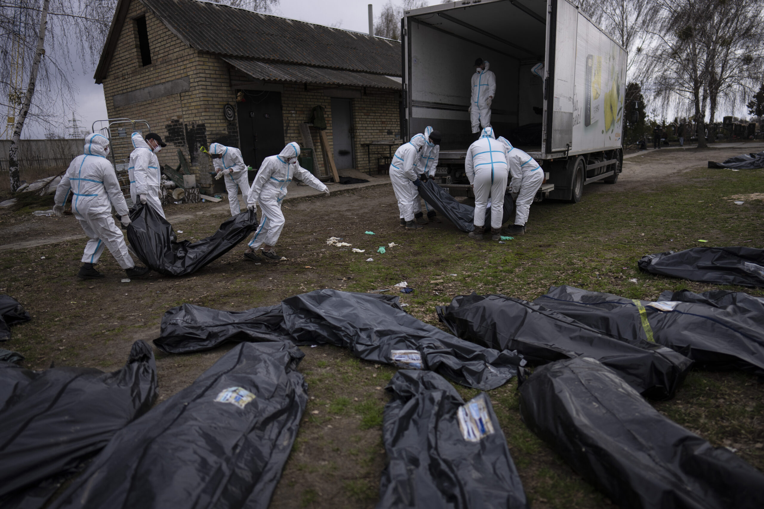 Los voluntarios cargan los cuerpos de los civiles asesinados en Bucza en un camión y los transportan a la morgue para su investigación.