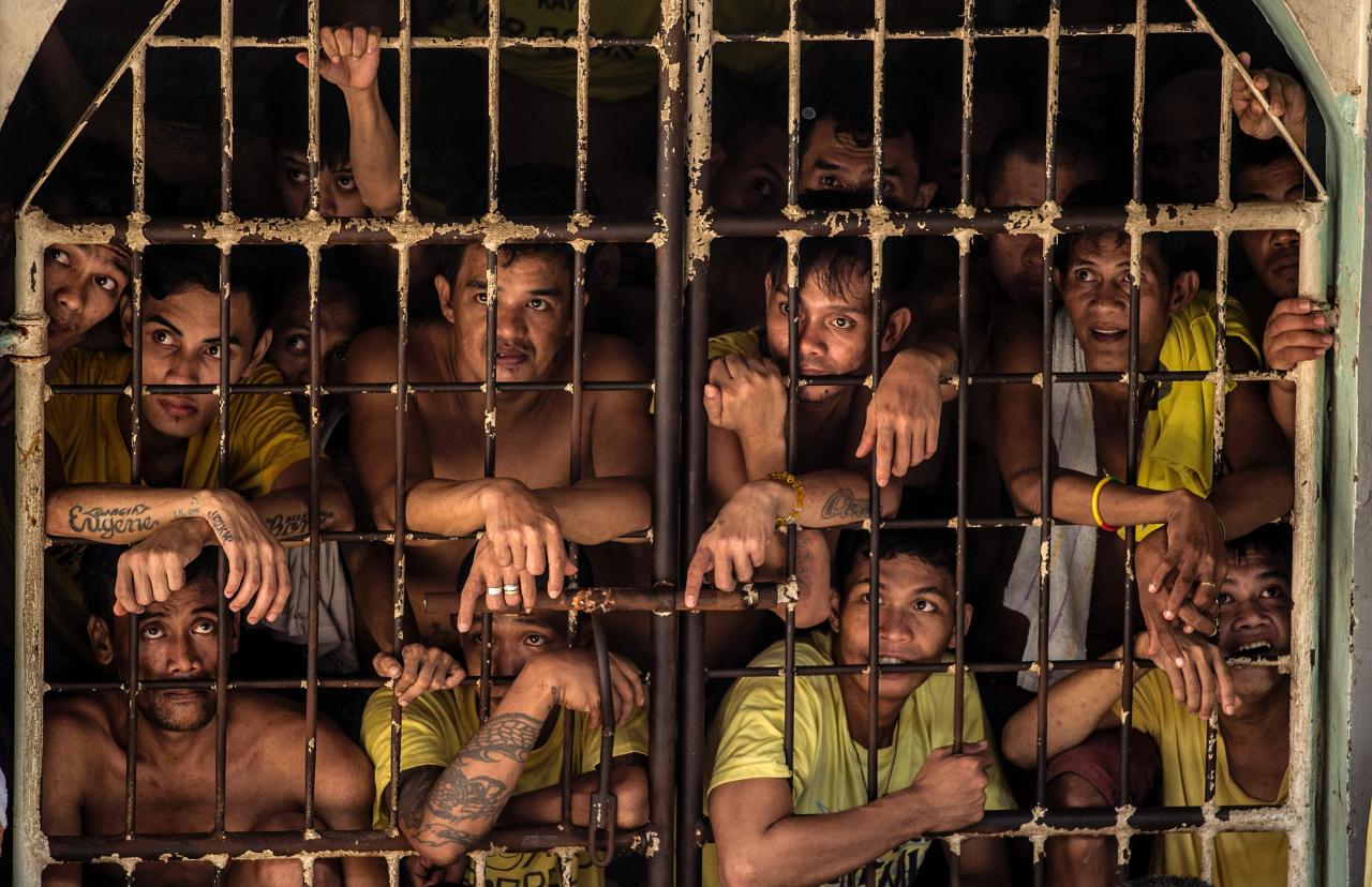 Los reclusos miran desde una celda en la prisión de Quezon City en Manila.