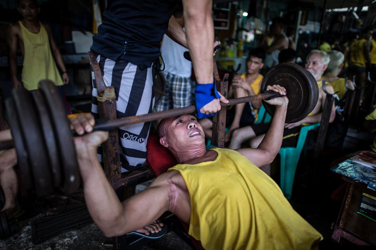 Un recluso levanta pesas en un gimnasio en una prisión de Manila.