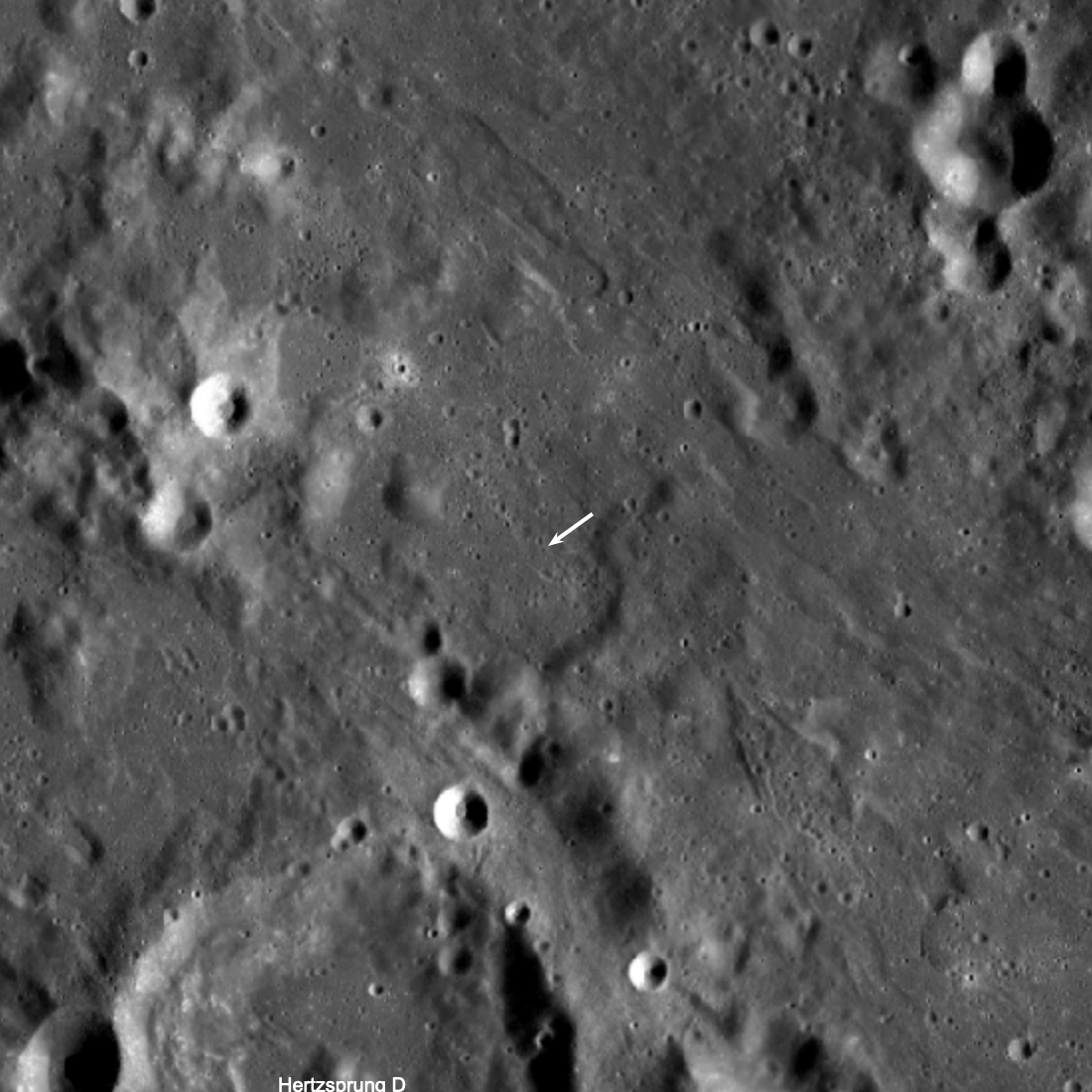 Una parte misteriosa del cohete chocó con la Luna en marzo, dejando un cráter de impacto inusual subrayado por la flecha blanca arriba