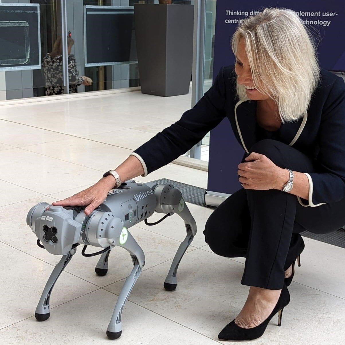 El titular del Ministerio de Justicia Jo Farrar se fotografió con el perro robot en un encuentro de innovaciones tecnológicas