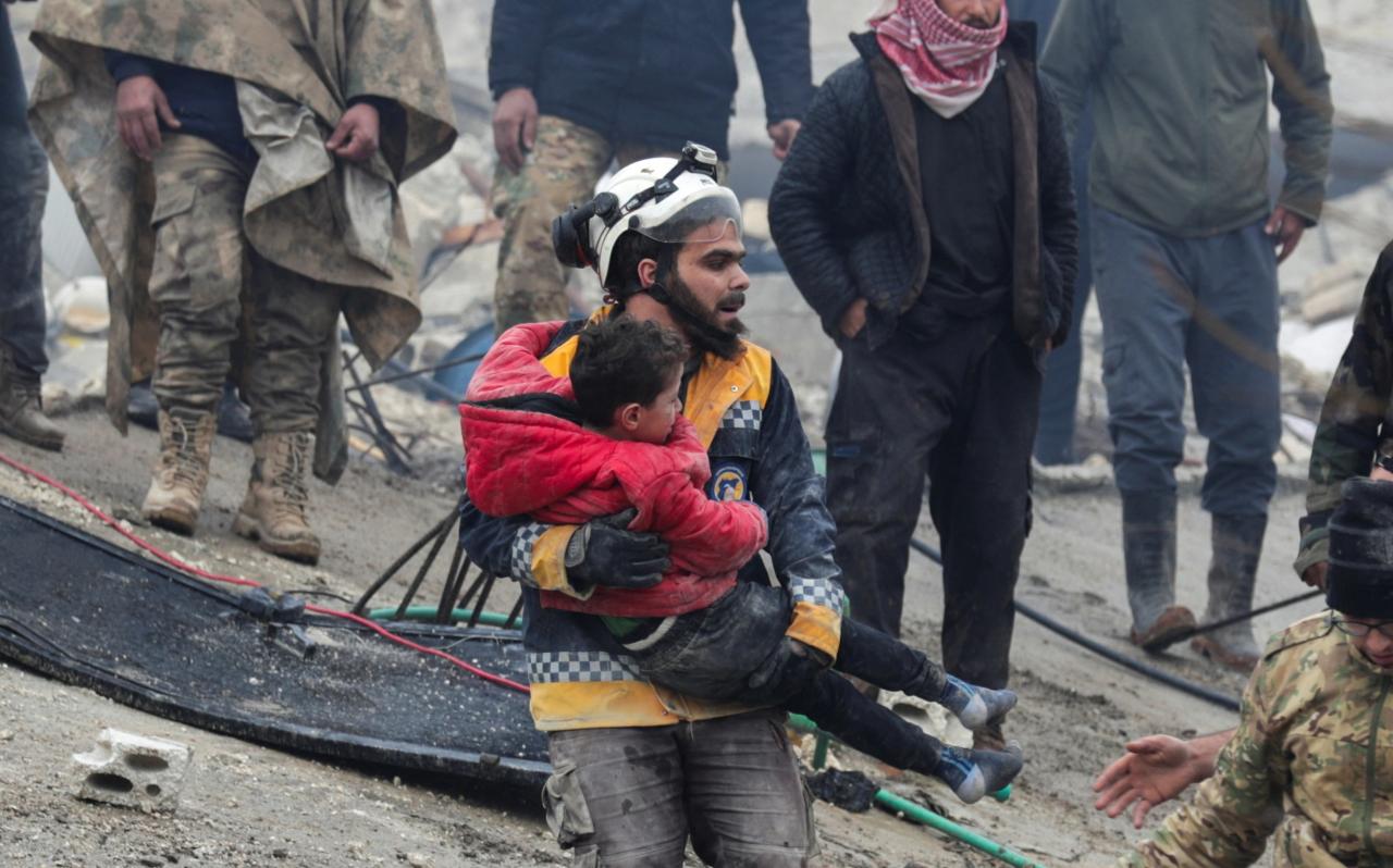 Un rescatista carga a un niño tras el terremoto en Siria